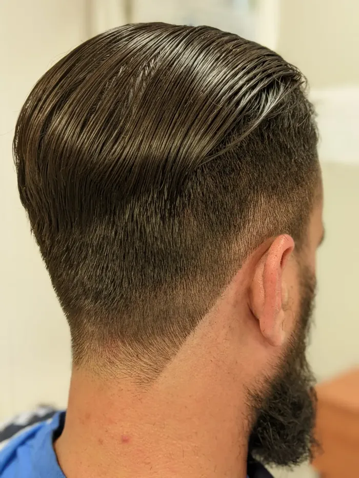 Coupe homme peignée vers l’arrière et barbe taillée