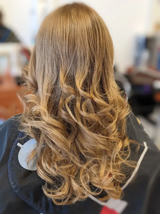 Mise en plis bouclée sur cheveux longs blonds